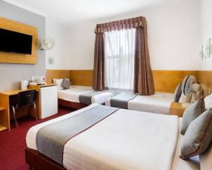 a hotel room with two beds and a desk at siadiw GuestHouse in Cikaroya