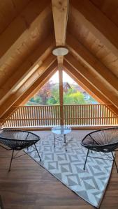 巴特泰納赫–察費爾施泰因的住宿－TinyLoft，门廊上设有2把椅子和1张桌子的屋顶