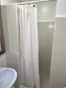 a bathroom with a shower curtain and a sink at City condo in Talisay