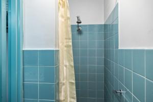 a bathroom with a shower with blue tiles at Red Carpet Motel in Mount Gambier
