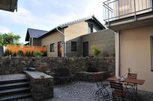 a patio with a stone wall next to a house at Vulkanhotel balance&selfness ***S in Steffeln