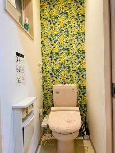 a bathroom with a toilet and a wall covered in bananas at 無料駐車場 3階建て一軒家 家族グループ最適 3寝室ヴィラ Usj 道頓堀 難波近い 子連れ歓迎 in Osaka