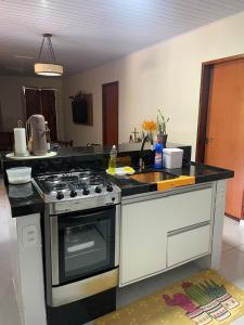a kitchen with a stove and a sink at Casa Bela Vista in Piranhas
