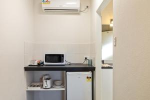 a small kitchen with a microwave and a refrigerator at Red Carpet Motel in Mount Gambier