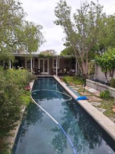 a swimming pool with a hose in front of a house at Rhus Cottage. in Stanford