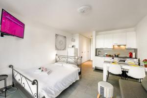 una camera con letto bianco e una cucina di Holiday Home With Pool In Agno - Happy Rentals ad Agno