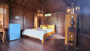 a bedroom with a bed with a pink duck on it at Suka Beach Bungalow in Nusa Lembongan