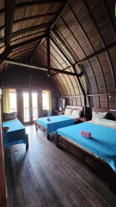 a large room with two beds in it at Suka Beach Bungalow in Nusa Lembongan