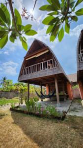 a small house with a thatched roof with a hammock at Suka Beach Bungalow in Nusa Lembongan +19 photos