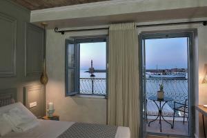 Schlafzimmer mit einem Bett und Blick auf einen Balkon in der Unterkunft Elia Zampeliou Hotel in Chania