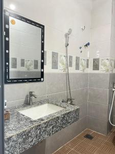 bagno con lavandino e doccia di KHÁCH SẠN HOÀNG QUANG a Biđong