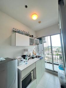 a kitchen with white appliances and a large window at Baan Kiang Fah by Thita Sea View in Hua Hin