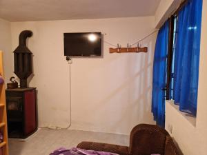 ein Wohnzimmer mit einem TV an der Wand in der Unterkunft Zavojsko jezero - kuća Mitić in Pirot