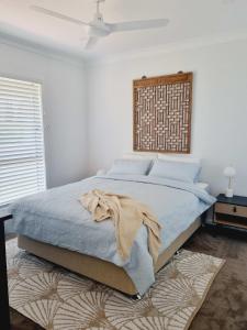 a bedroom with a bed with a blanket on it at Surfmist House in Robe