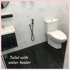 a bathroom with a white toilet and a sink at Homestay Villa Muslim Kuala Terengganu with pool and parking in Kuala Terengganu