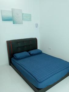 クアラ・トレンガヌにあるHomestay Villa Muslim Kuala Terengganu with pool and parkingの青い枕が付いたベッド1台が備わる客室です。