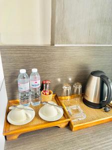 ein Tablett mit Tellern und Wasserflaschen sowie einem Wasserkocher in der Unterkunft Phi Phi Mountain Beach Resort SHA Certified in Ko Phi Phi
