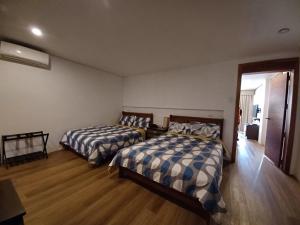 two beds in a room with wooden floors at QM Diving Resort in Basdiot