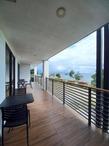 a balcony with a table and chairs and a view of the ocean at QM Diving Resort in Basdiot