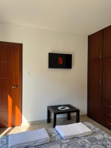 a bedroom with a table and a tv on the wall at Brand new Holiday Villa - 3 bedroom 4 bathroom in Baños