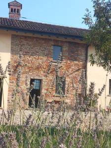 ein Backsteinhaus mit einer Veranda und einem Fenster in der Unterkunft Agriturismo Cascina Pezzolo in Lodi