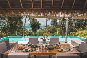 a wooden table with food on it next to a pool at Villa Escape Burasari in Phuket