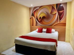 1 dormitorio con 1 cama con una pintura en la pared en RedDoorz near Gedung Kesenian Palopo, en Palopo