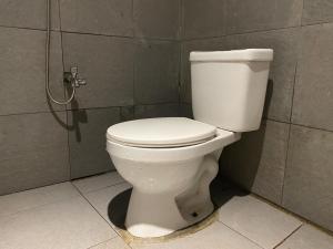 een wit toilet in een badkamer met een douche bij RedDoorz near Gedung Kesenian Palopo in Palopo