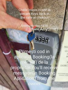 a person holding a pair of keys next to a cell phone at MAXX Lodge in Bacău