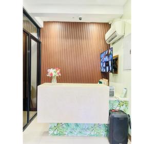 a reception counter with a vase of flowers on it at OYO 1008 Armond Bed And Breakfast in Mactan