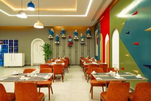 a restaurant with tables and chairs in a room at Pickalbatros Jungle Aqua Park - Neverland Hurghada in Hurghada +238 photos