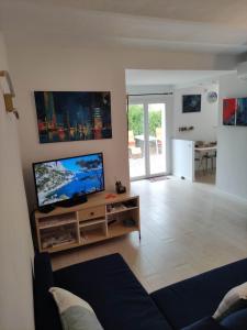 uma sala de estar com uma grande televisão de ecrã plano em La Bastide, 100m des rues piétonnes, jardin em Sanary-sur-Mer