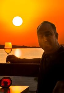 a man sitting at a table with a glass of wine at Casa Rasaritul Soarelui Sarichioi in Sarichioi +40 photos
