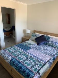 una camera da letto con un letto con una trapunta blu sopra di Ocean View 2 Brm Marine Pde Royal Pacific a Kingscliff