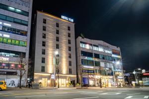 dois edifícios altos em uma rua da cidade à noite em Goyang Hotel Yuji em Goyang