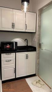 eine Küche mit weißen Schränken und einem weißen Kühlschrank in der Unterkunft Modern studio with self check-in in Riad
