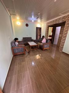 two men sitting on couches in a living room at Résidence Agnès et Victor (RAV) in Bangui