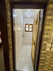 a bathroom with a walk in shower and a door at Résidence Agnès et Victor (RAV) in Bangui