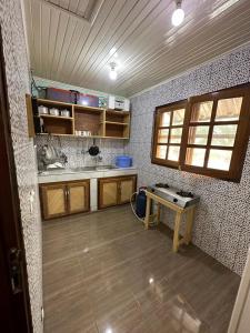 a kitchen with wooden cabinets and a table in it at Résidence Agnès et Victor (RAV) in Bangui