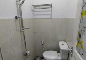 a small bathroom with a toilet and a shower at Hotel Agung Putra in Banyumas