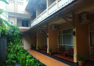 a corridor of a building with a balcony and plants at Hotel Agung Putra in Banyumas