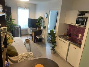 a kitchen and living room with a couch and a table at Cosy arena in Nîmes