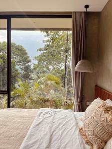 a bedroom with a bed and a large window at THE HILL By The Villas 100 in Bogor +109 photos