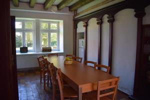 comedor con mesa de madera y sillas en Zámeček nad Běleckým Mlýnem 