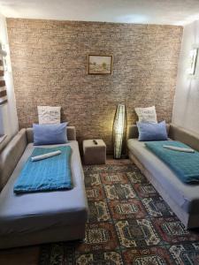 een kamer met 2 bedden en een bakstenen muur bij Apartmani Villas in Visoko