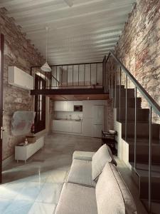 Una sala de estar con una escalera y un sofá. en Apartamentos Arraez, en Almería
