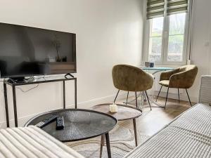 a living room with a couch and a table and chairs at Le Huitième - Proche centre ville in Compiègne