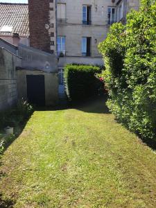 une cour devant un bâtiment avec des buissons dans l'établissement Le Huitième - Chic et Branché, à Compiègne