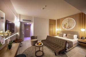 a hotel room with a bed and a couch at NissiBlu Beach Resort in Ayia Napa