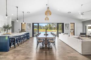 a kitchen and living room with a table and chairs at Koala Lane in Bonville